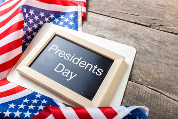 the text happy presidents day written in a chalkboard and a flag of the United States