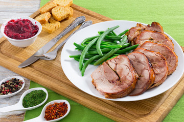 turkey roulade cut in slices with boiled green beans, close-up