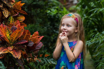 emotional portrait of a surprised girl in a botanical garden near the plant