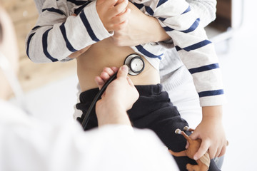Doctor is applying a stethoscope to children