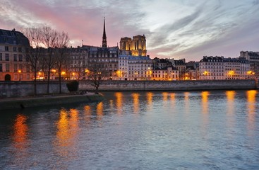 Fototapeta premium Beautiful pink sky at sunset over the Notre-Dame cathedral and the Seine River in Paris, France
