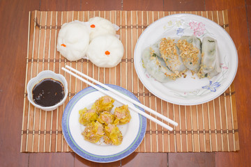 Steamed stuff bun (Salapao) and dumpling on mat bamboo.
