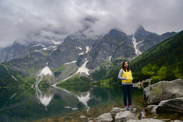 Fototapeta premium woman relaxing on the lake and mountains sunny landscape