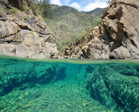Half and half over and under the water in a river with rocks, New Caledonia, Dumbea river

