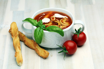 Tomato, red pepper soup, sauce with olive oil, rosemary and smoked paprika on a wooden background. 