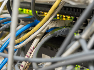 Rj45 plug connected to network gigabit switch in a datacenter room. Lights, link, internet, web, server, patch coard.