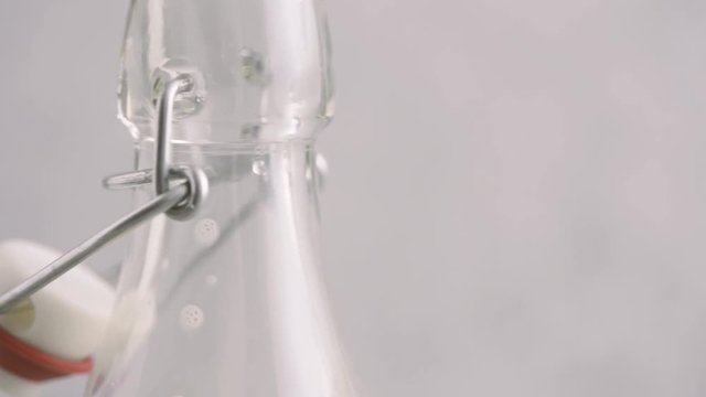 Soy milk in a glass in close up. Placing striped drinking straw. Film clip of vegan dairy drink.