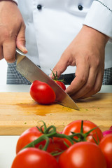 professional hands chopped tomatoes on a wooden board