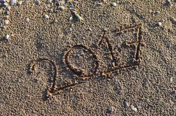 2017 handwritten in sand in a sunny day .