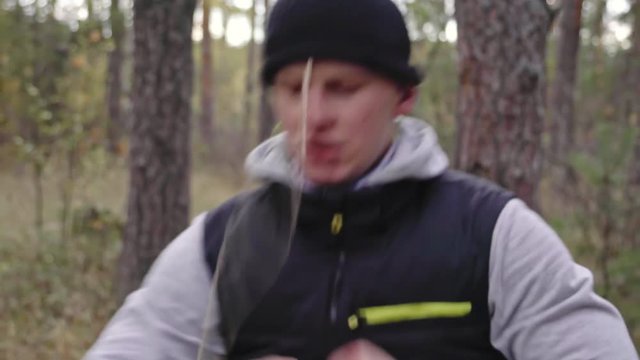 Dolly shot of concentrated man exercising with boxing tennis ball hat in forest area