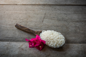 Rice on Wooden Spoons on wooden background