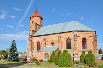 Fototapeta na wymiar Old Catholic Church of red brick in the Gothic style in the village Gniezno, Grodno region, Belarus.