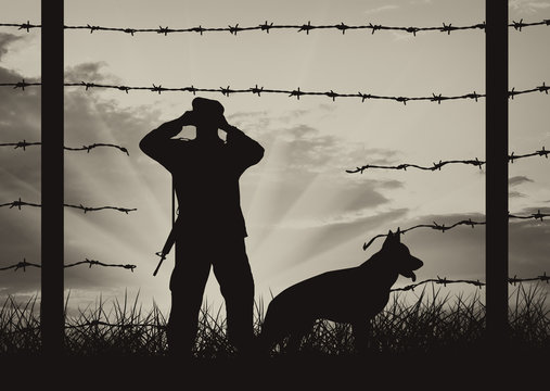 Hole in fence on border and border guards with dog