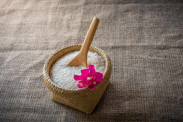 Wooden Spoons and basket of jasmine rice on wooden