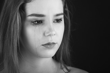 Fototapeta premium sad woman crying on black background, monochrome