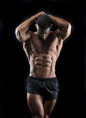 Obraz na płótnie Canvas Muscular man showing abs 