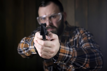 man with put on protective goggles and ear training in pistol sh