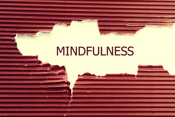 Mindfulness word written under torn paper