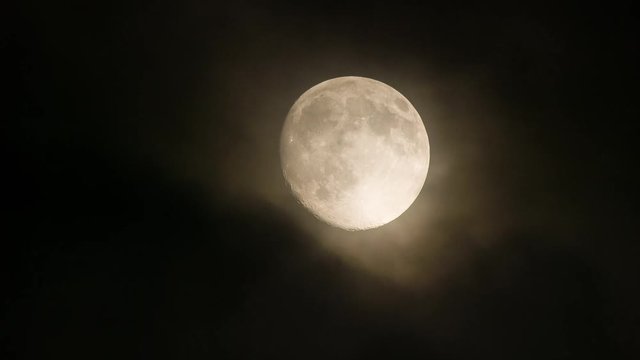 Close-up of a Super Moon with Mystical Clouds Moving Past