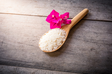 Rice on Wooden Spoons on wooden background