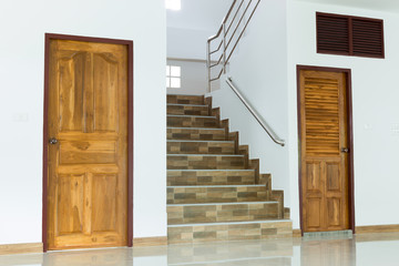 white empty room interior with wooden door and staircase