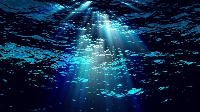 Underwater light filters down through blue water (Loop).