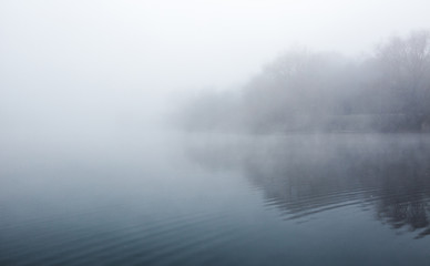 Mist hovering over a cold lake in Goldsworth Park, Surrey, Wokin