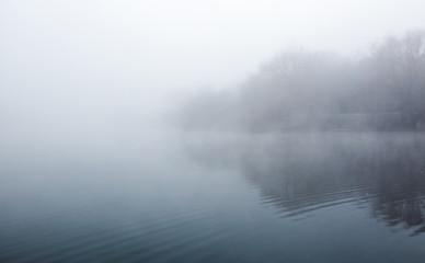 Mist hovering over a cold lake in Goldsworth Park, Surrey, Wokin