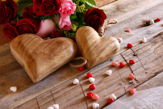 Red hearts and roses on wooden table
