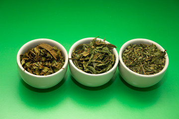green tea different grinding in white bowls on green background
