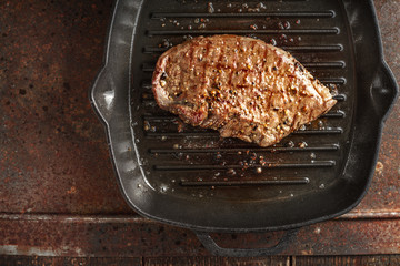 Roast beef steak in spices on pan grill