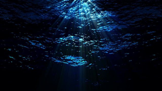 Dark underwater ocean waves ripple and flow with light rays (Loop).