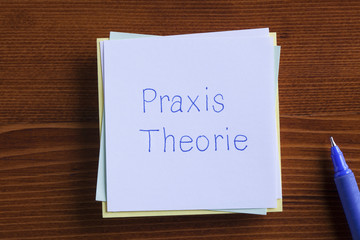 Theory and Practice in German written on a note.Praxis Theorie