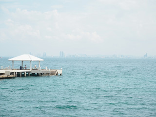 concrete pier on sea/ocean with blue sky background in Thailand.