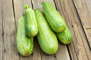 Green zucchini on wooden board