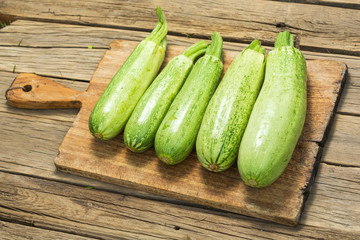Green zucchini on wooden cutting board