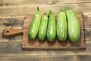 Green zucchini on wooden cutting board