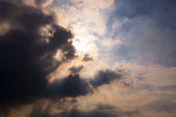 Naklejka na ściany i meble Sun behind clouds background
