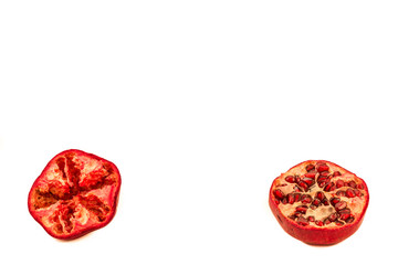 Two halves of pomegranate on a white background one seedless one with seeds