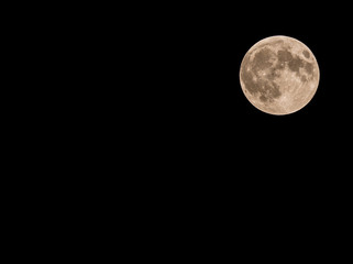 Full moon over dark black sky in pitch black night