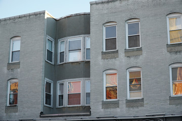 Fototapeta na wymiar close up facade view of apartment building with windows reflecting sunset light