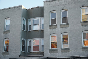 Obraz premium close up facade view of apartment building with windows reflecting sunset light