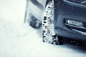 Closeup of car tires on a snowy road.Blizzard on the road.