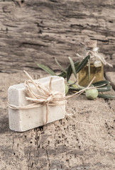 natural olive oil soap bar and oil bottle on wooden table