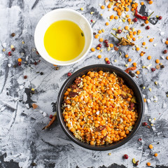 Lentils, bulgur, wheat cereal, dried tomatoes and onion with olive oil on a marble background. Ingredients for dinner. Top view