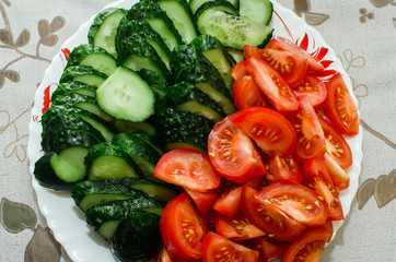 sliced tomatoes and cucumbers lie on a plate, close-up