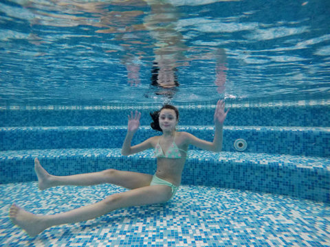 Beautiful girl 14 floats under water in the pool