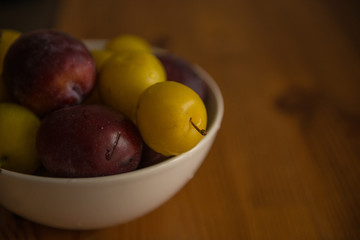 Naklejka na ściany i meble Close view of raw plums in bowl