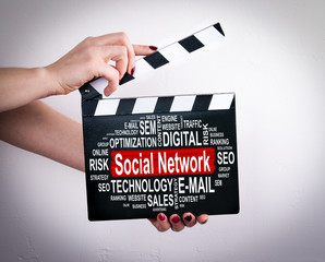 Social Network concept. Tablet computer concept. Female hands holding movie clapper. 