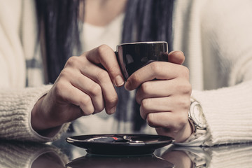 Fototapeta na wymiar Young Woman drinking coffee / tea in a coffee shop